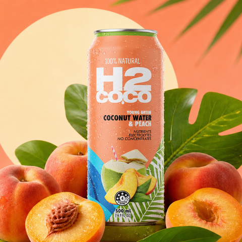 A can of H2 Coco Coconut Water & Peach beverage stands upright among whole and sliced peaches with green leaves on a peach and orange graphic background with the word PEACH.